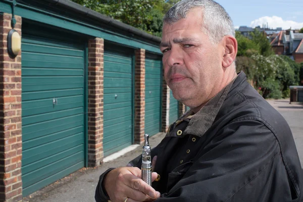 Мужчина средних лет курит электронную сигарету — стоковое фото