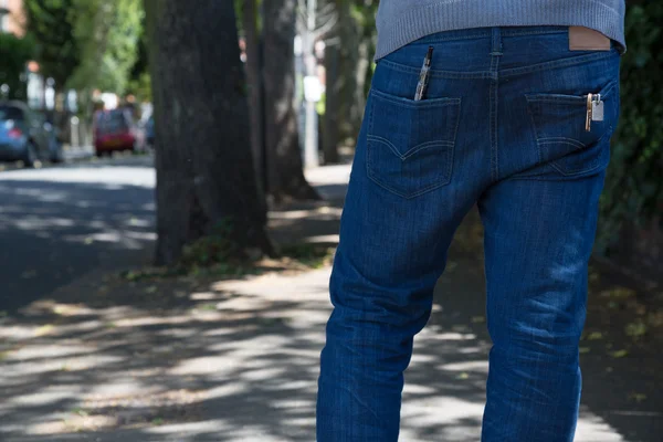 Traseira do homem vestindo calças de ganga azuis andando ao ar livre — Fotografia de Stock