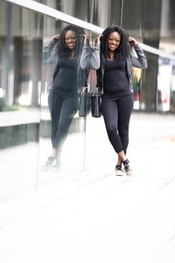 Gülümseyen bir kentsel sokakta hayat dolu genç kadın