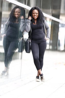 Cam duvara yaslanmış mutlu siyah kadın