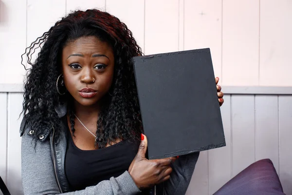 Młody czarny kobieta trzyma mały czarny deska — Zdjęcie stockowe