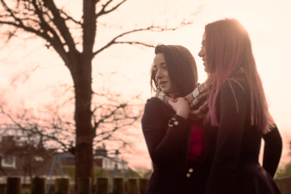 Zwei Mädchen im Teenageralter bei Sonnenuntergang draußen Stockbild