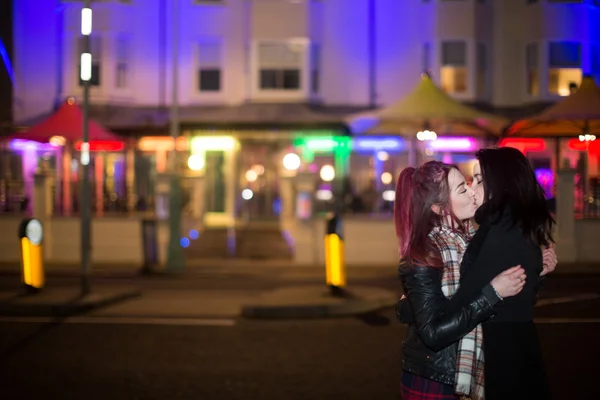 Femmina stesso sesso coppia baci all'aperto a notte Foto Stock Royalty Free