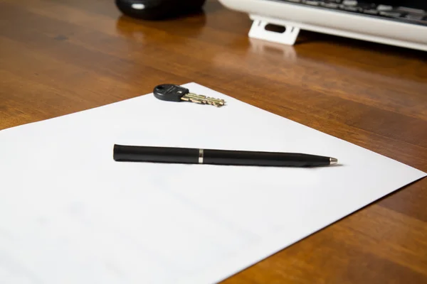 Papel em branco na mesa com caneta e chave — Fotografia de Stock