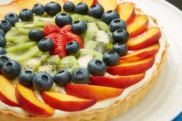 Frutas frescas en la parte superior de la torta sabrosa con glaseado Fotos de stock libres de derechos