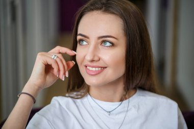 Genç bir kadın kanepede oturuyor ve işten uzak bir dizüstü bilgisayarla çalışıyor. Dizlerinin üstünde bilgisayarı olan bir kız monitöre bakıyor.