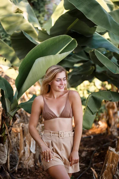美しい少女がヤシの木の近くの美しいポーズに立って バナナ農園での肖像画撮影 — ストック写真
