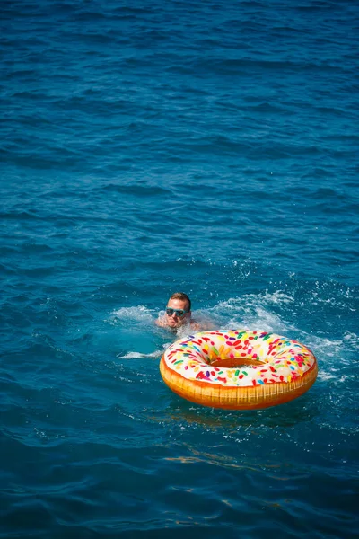 Ung Man Flyter Uppblåsbar Ring Havet Med Blått Vatten Festlig — Stockfoto