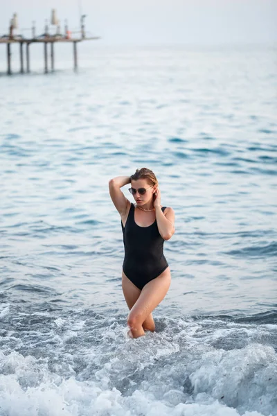 수영복을 아름다운 여인이 금발의 머리를 해변에서 해변에 펼치고 해변을 — 스톡 사진