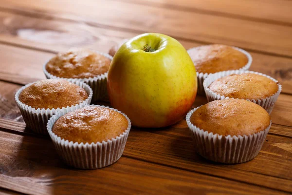 Σπιτικά Muffins Χάρτινη Μεμβράνη Ένα Μήλο Ξύλινη Σανίδα — Φωτογραφία Αρχείου