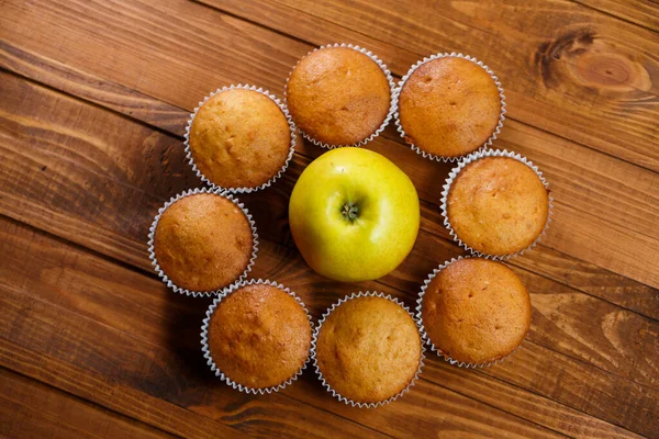 Σπιτικά Muffins Χάρτινη Μεμβράνη Ένα Μήλο Ξύλινη Σανίδα — Φωτογραφία Αρχείου