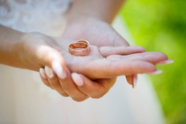 Altın alyanslar düğün gününde yeni evlilerin ellerinde.