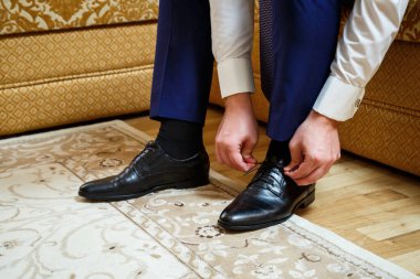 Bir adam düğün günü erkek kıyafeti giyer.