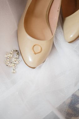 Düğün gününde kadın ayakkabılı altın alyans.
