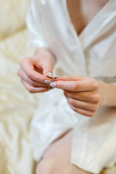 золотые обручальные кольца в руках молодоженов в день свадьбы