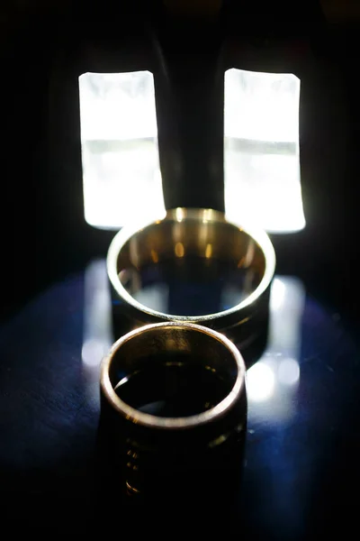 ブラックガラス上の金の結婚指輪 — ストック写真