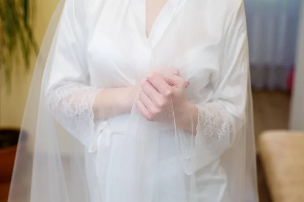 Mariées mains pliées sur une robe de mariée blanche — Photo