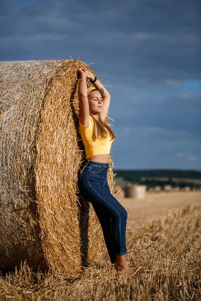 Молодая Красивая Блондинка Стоит Скошенном Пшеничном Поле Рядом Огромным Снопом — стоковое фото