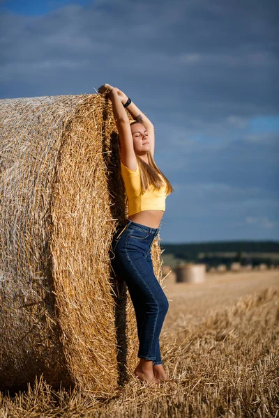 Молодая Красивая Блондинка Стоит Скошенном Пшеничном Поле Рядом Огромным Снопом — стоковое фото