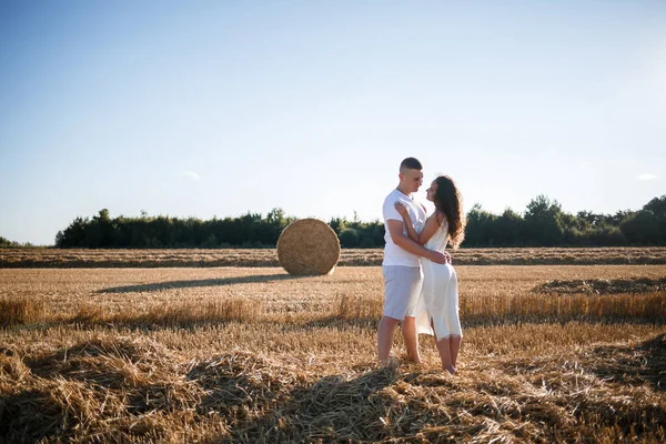 一个迷人的女人站在割下的麦田里 手里拿着一捆麦子 收割后 田里的草包 是一对漂亮的斯拉夫夫妇拍照的地方 — 图库照片