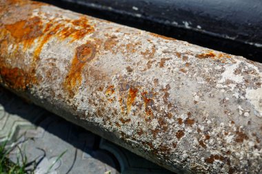 Betonun üzerinde büyük, paslı bir boru var.