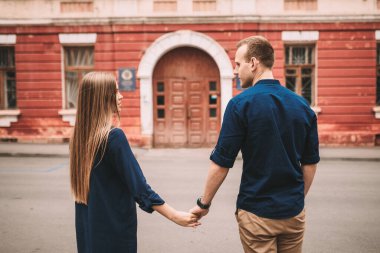 Kırmızı eski kapıların arkasında mutlu, güzel, genç bir çift. Mutlu aile kavramı