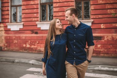 Şehirde yaya geçidinde yürüyen mutlu bir çift.