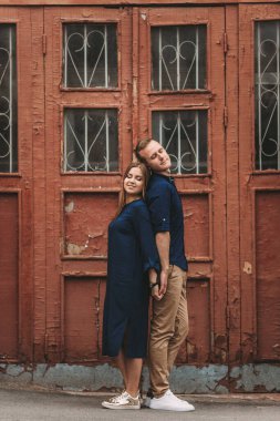 Kırmızı eski kapıların arkasında mutlu, güzel, genç bir çift. Mutlu aile kavramı