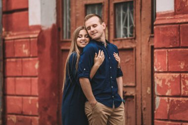 Kırmızı eski kapıların arkasında mutlu, güzel, genç bir çift. Mutlu aile kavramı