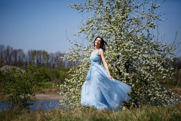 Egy Kék Ruhás Érzékeny Lány Portréja Egy Virágzó Alatt Mosollyal — Stock Fotó