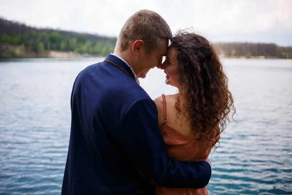 Jovem Casal Mãos Dadas Uma Ponte Madeira Meio Lago Azul — Fotografia de Stock