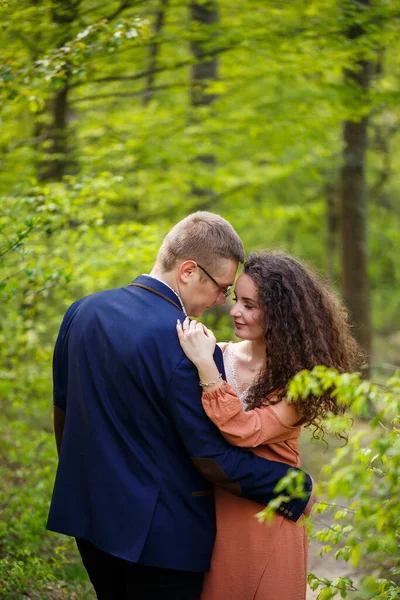一对年轻夫妇在青翠的森林里浪漫地散步 温暖的春天天气 男孩和女孩在大自然中拥抱 — 图库照片