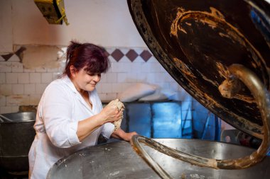 Bir pasta ve pastane işçisinin dev bir mikserden hamur işi yapan bir pasta ve pastane çalışanının hayat tarzı fotoğrafı.