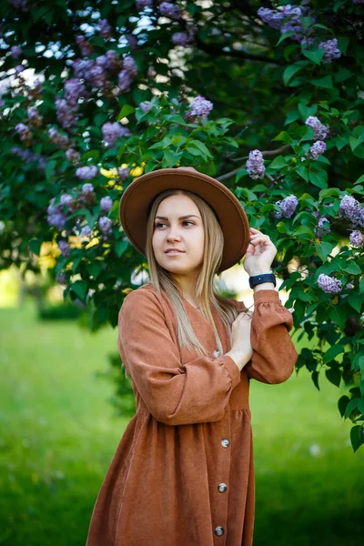 Porträtt Snygg Flicka Brun Hatt Och Klänning Bakgrund Syrener Träd — Stockfoto