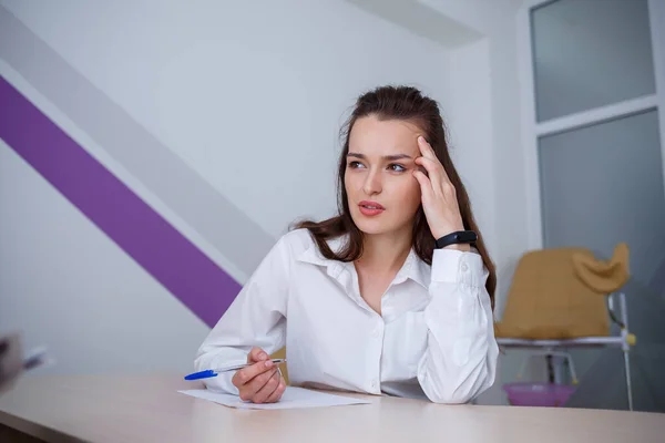 Eine Schöne Junge Frau Sitzt Einem Tisch Und Signiert Wichtige — Stockfoto