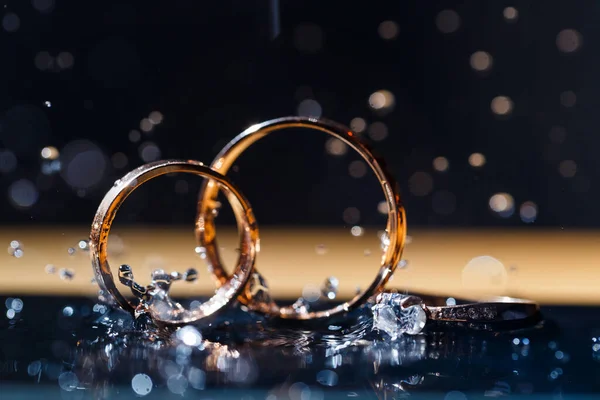 Arany Jegygyűrűk Friss Házasoknak Esküvő Napján Fekete Alapon Vízcseppekkel Ékszerek — Stock Fotó