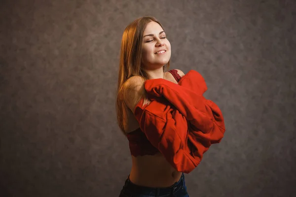 女の子試行上の赤いセーター上の灰色の背景 — ストック写真