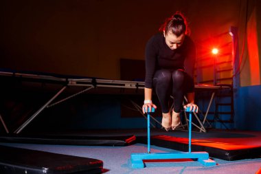 Yoga yapan genç çekici bir kadın, el dengesi egzersizi, amuda kalkma, spor kıyafetleri, siyah taytlar ve üstte, kapalı alanda tam gelişim.