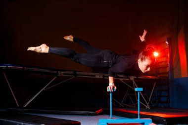 Yoga yapan genç çekici bir kadın, el dengesi egzersizi, amuda kalkma, spor kıyafetleri, siyah taytlar ve üstte, kapalı alanda tam gelişim.