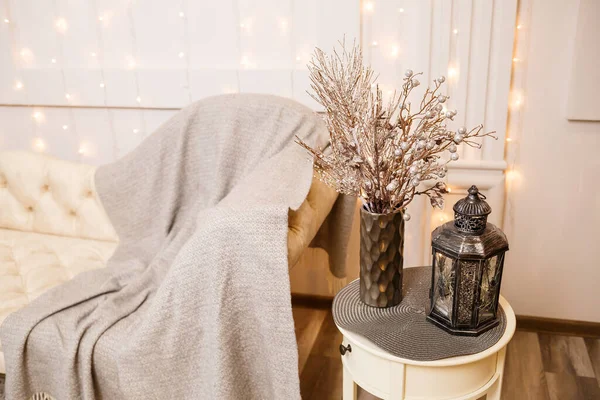 Decorative antique silver retro lamp on a white small table in the living room. Interior decor in the house.