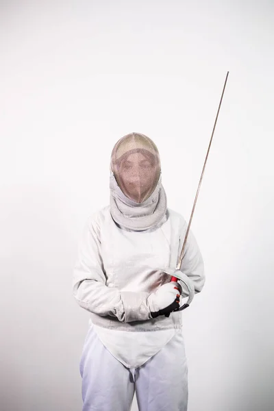 Chica con un disfraz de esgrima con una espada en la mano aislada en el fondo del estudio blanco. Las chicas jóvenes practican y hacen ejercicio. Deportes, estilo de vida saludable. —  Fotos de Stock