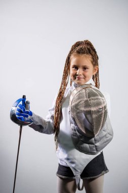 Eskrim kostümü giymiş bir çocuk çiş tutuyor. Kız eskrim öğreniyor