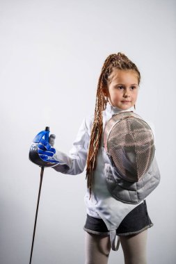 Eskrim kostümü giymiş bir çocuk çiş tutuyor. Kız eskrim öğreniyor