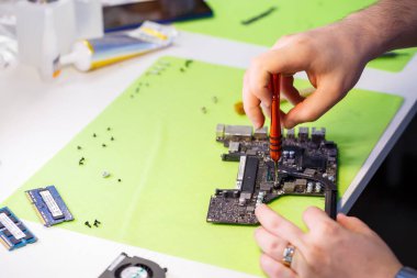 Profesyonel bilgisayar ve tablet tamir atölyesi veya servis. Bir bilgisayar panosunu kapat. Elektronik konsept. Onarımda olan bir dizüstü bilgisayarın ayrıntıları