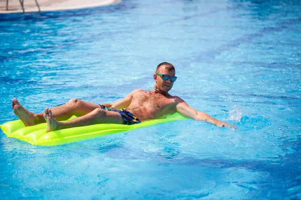 Een Jongeman Baadt Het Zwembad Een Gele Opblaasbare Matras Ontspan — Stockfoto