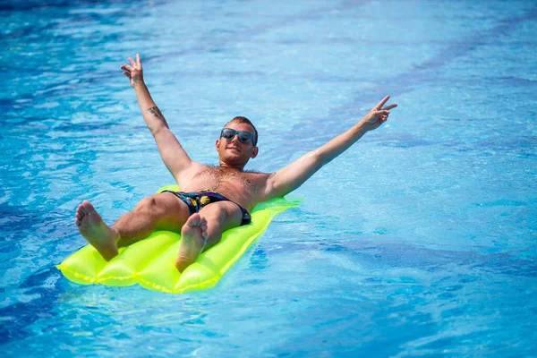 Een Jongeman Baadt Het Zwembad Een Gele Opblaasbare Matras Ontspan — Stockfoto
