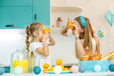 Mutlu genç anne, evdeki mutfakta kızı için kruvasan pişiriyor. Mutlu aile ilişkileri