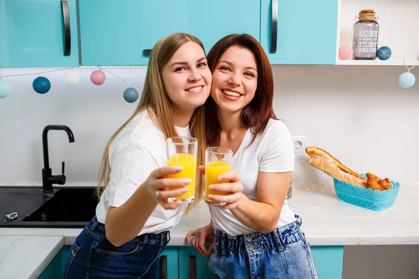 Due Amiche Cucina Che Bevono Succo Arancia Fidanzate Chiacchierare Condividere — Foto Stock