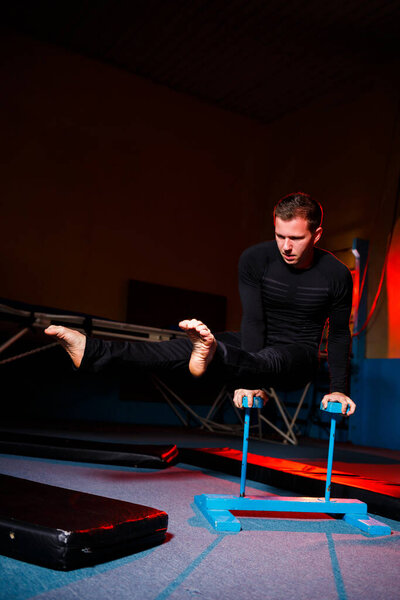 Portrait of a gymnast man in sportswear, man doing exercises on a horse in the gym