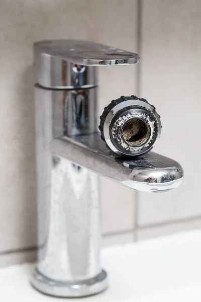 Broken tap in the bathroom sink. Splashing water from a silver faucet